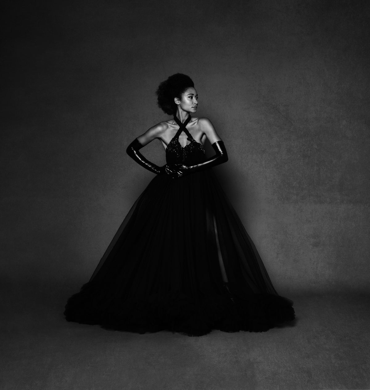 Model in a black Zoba Martin couture dress: a tulle ball gown with crossed halter, beaded bodice and opera gloves.
